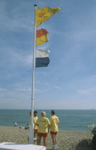 Lifeguards on beach under flag pole