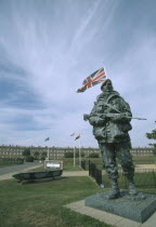 Royal Marines Museum. Large statue of a Royal Marine holding gun on display in front of building and Union Jack flag flying behind