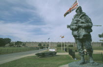 Royal Marines Museum. Large statue of a Royal Marine holding gun on display in front of building and Union Jack flag flying behind