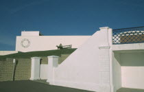 De La Warr Pavilion. Exterior view from promenade towards the Pavilions white terrace and wall with the circular silver Art Deco metal sign with a woman sat on bench. Art Deco building built by the E...