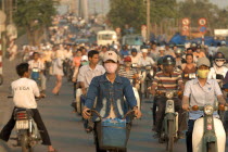 Busy street with people riding motorbikes and bicycles
