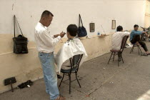 Men cutting hair in a hair Salon on the street