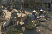 Fruit sellers wearing conical hats on the street in the centre of town
