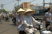 Monks in conical hats riding a a motorbike
