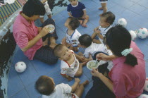Staff feeding young children in Vienping Orphanage.
