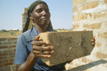 Woman in Mshikimano squatter settlement taught to make bricks for building her house.