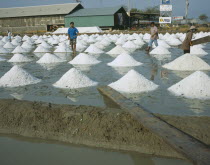 Three people working at Salt pans outside Bangkok on the road to Ratchaburi