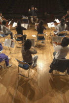 United Freedom Orchestra rehearsing for spring concert Junior and senior high school students  13 to 18 years old  top center is conductor and music teacher Satoshi Miyano