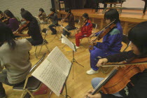 Junior and senior high school girls playing violin and viola.Members of United Freedom Orchestra