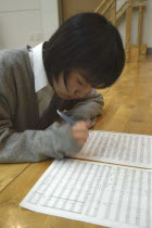 Teenage girl writing notes on her sheet music. Plays Violin in United Freedom OrchestraEmi Katori  16 years old  high school 1st year girl