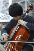 Teenage boy playing cello as member of United Freedom OrchestraShyota Oki  17 years old  3rd year high school boy