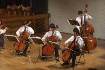 Teenage Cello players performing on stage at the spring concert of the United Freedom Orchestraboys  16- 18 years old