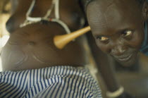 Traditional midwife Josephine listening to foetal heart during examination of patient.