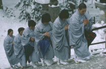 Mount Koya-san.  Venerated Shingon-Buddhist site.  Novice nuns climbing steps in heavy snow.