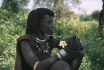 Portrait of Hamer woman holding frangipani flower.