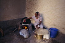 Woman cooking injera  a type of sour  flat bread that accompanies most meals.