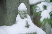 Zen Buddhist grave and statue in snow.