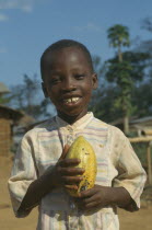 Portrait of child holding cocoa pod.