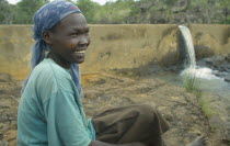 Pauline Rerimoi beside dam she built.  Previously she had had to carry a twenty litre container of water along cliff paths in a four hour trip.