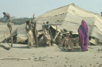 Beja women and children outside tent made from woven palm matting designed to be moveable so as to be able to follow the herds.Nomadic African arab tribe