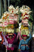 Women carrying towers of fruit and flower offerings at Mengwi Festival.