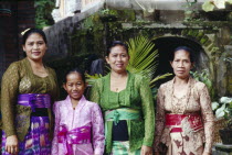 Family group of women and young girl on way to temple.