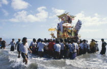 Cremation celebrations.  Crowds carrying cremation tower accompanied by musicians out to sea.pengabenanpalebonan