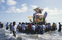 Cremation celebrations.  Crowds carrying cremation tower accompanied by musicians out to sea.pengabenanpalebonan