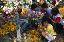 Tzurumutaro Cemetery.  Woman and children making graveside vigil as part of Day of the Dead celebrations.