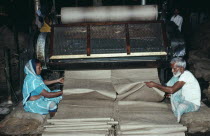 Male and female workers in Fort Gloster jute mill drawing out lengths of jute from machinery. Kolkata