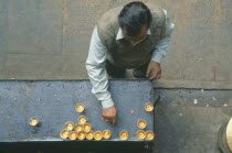 Looking down on man lighting butterwick candles at the Hiranyavarna Mahavihara Golden Temple