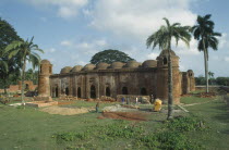 Ancient mosque built from bricks and terracotta with construction workers in the foreground.muslim  moslem  islam