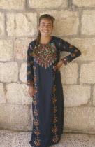 Young woman in traditional Palestinian embroidered dress in National colours