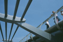 Section of the underside of the Millennium footbridge with pedestrians looking over the side