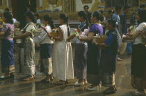 Line of young women with offerings for the Awk Phansaa festival.d