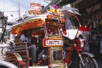 Moriones Festival. Close up of brightly coloured tricycle with pasengers in side cart