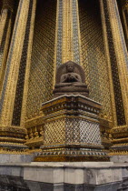 Or Grand Palace. Seated buddha statue sitting against golden exterior wall