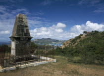 Memorial to members of the Dorset Regiment who died in the 1940s  surrounded by railings with view towards Falmouth and English Harbour behind.