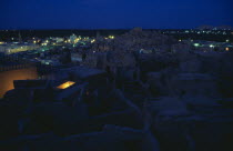 View across town towards Shali Fortress at night with oasis in the background