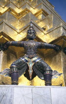 Or Grand Palace. Detail of statue standing against golden wall