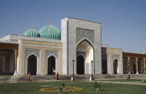 Al Bukhari Mausoleum facade and lawns with passing people