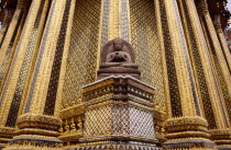 Grand Palace  Wat Phra Kaeo. Seated Buddha statue with ornately decorated golden exterior walls of temple