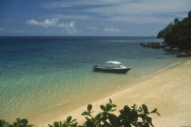 Small boat moored on the shore of a sandy beach on the west coast of the island.