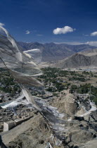 Prayer Flags flying over village surrounded by mountain range