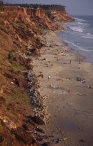 Beach sheltered by cliffs with bathers on the sand