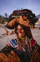 Portrait of a beach cloth vendor carrying her wares on her head