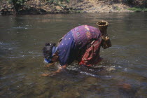 Mae Lui village. Karen refugee woman gathering shellfish by hand using a snorkel