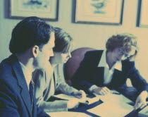 Two women & man at business meeting