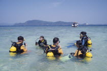 Also known as Coral Island. Tourists having scuba diving lessons in the clear waters with nearby boat