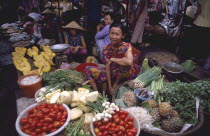 Nha Trang. Vegetable market vendor sitting behind displays of goods